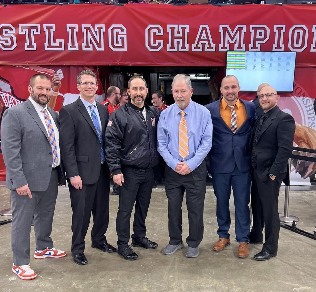 Jim Wegesin, in blue shirt, poses after the Hall of Fame ceremony with five of his former wrestlers at Galion High School.
(L to R) Galion head coach Brent Tyrrell, Highland head coach Adam Gilmore, son Brady Wegesin, Galion athletic director and assistant coach Matt Tyrrell, and Jeremiah Webber, head coach at Dublin Coffman.