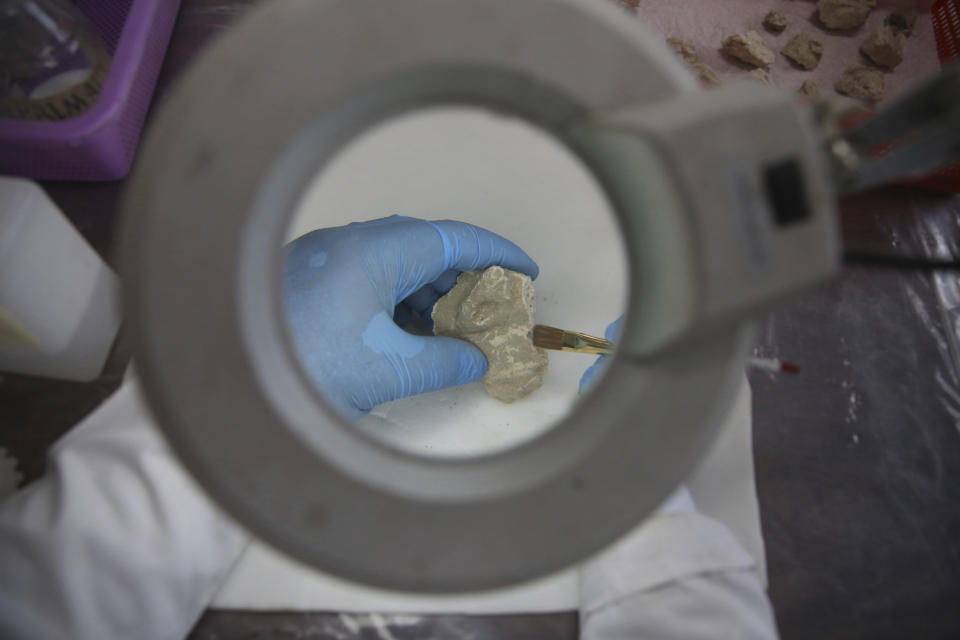 In this Saturday, Aug. 17, 2019 photo, conservator M. Ghufran Hanifi works on a piece of a small statue that was damaged by the Taliban because they were judged to be against Islam, at the National Museum of Afghanistan in Kabul, Afghanistan. What the Taliban fighters left behind is laid out on tables at the National Museum of Afghanistan, 18 years later. Museum workers in Kabul have been trying to fit them together again as a nervous country waits for the Taliban and the U.S. to reach a deal on ending America’s longest war. (AP Photo/Rafiq Maqbool)