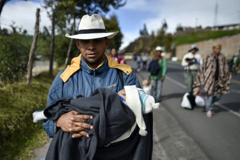 Richard Lomelly, 30, carries baby Tiago along the highway between Pasto and Ipiales in Colombia, on their way to Peru