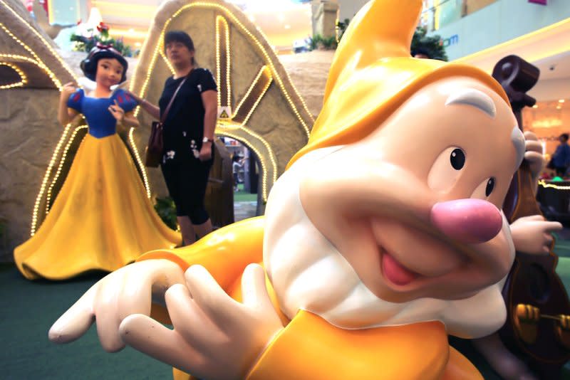 People pose for photos next to Walt Disney's "Snow White" figurines at a mall in Beijing on September 24, 2015. On December 21, 1937, Walt Disney's "Snow White and the Seven Dwarfs," the first full-length animated feature film, premiered in Los Angeles. File Photo by Stephen Shaver/UPI