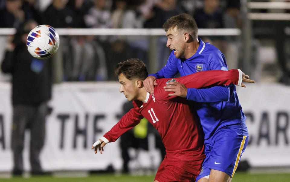 Indiana's Nyk Sessock (11) and Pittsburgh's Josh Luchini, right, compete for the ball during the first half of an NCAA men's soccer tournament semifinal in Cary, N.C., Friday, Dec. 9, 2022. (AP Photo/Ben McKeown)