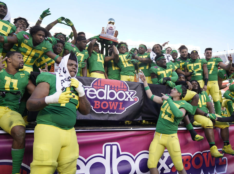 Oregon players hold the trophy after a 7-6 win over Michigan State during the Redbox Bowl NCAA college football game Monday, Dec. 31, 2018, in Santa Clara, California. (AP Photo/Tony Avelar)