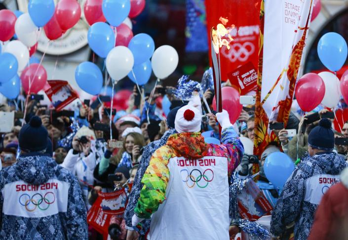 Alexey Voyevoda, a former Olympic bobsledder, who won silver in the 4-man bobsled in Turin in 2006, carries the Olympic torch as it makes it's way throughout the streets of the Rosa Khutor ski resort in Krasnaya Polyana, Russia at the Sochi 2014 Winter Olympics, Wednesday, Feb. 5, 2014. (AP Photo/Gero Breloer)