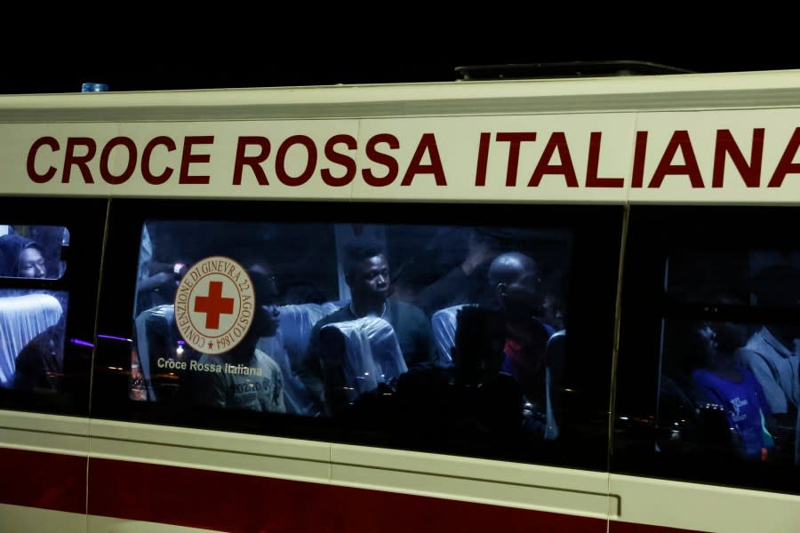 Rescued migrants sit in a bus after disembarking from a boat on the Italian island of Lampedusa during the evening of Saturday, Sept. 16, 2023. (Cecilia Fabiano/LaPresse via AP)