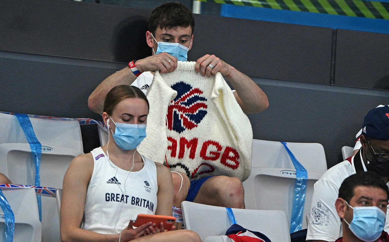 Thomas Daley with his knitting as he watches divers in the preliminary round of the men's 3m springboard diving event. (Oli Scarff / AFP via Getty Images)