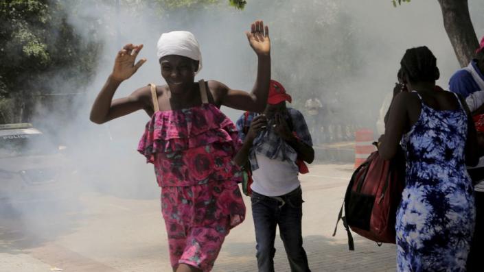 Haitians flee tear gas fired by officers clearing a camp of people at the US embassy seeking to escape the violence of armed gangs on July 25.  - Ralph Tedy Erol/Reuters