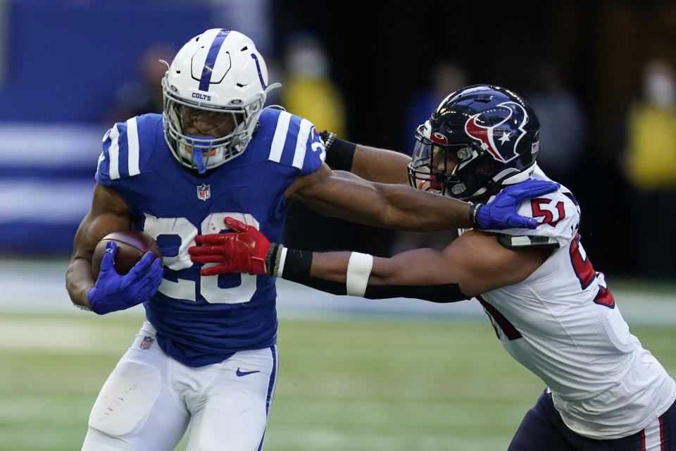 Indianapolis Colts' Jonathan Taylor (28) runs past Houston Texans' Kamu Grugier-Hill (51) during the second half of an NFL football game, Sunday, Oct. 17, 2021, in Indianapolis. (AP Photo/Michael Conroy)