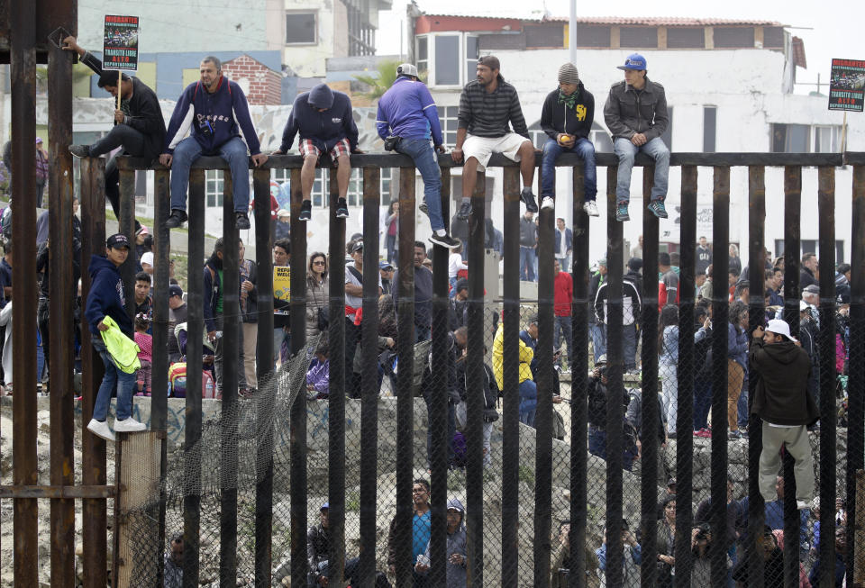 <p>Central American migrants sit on top of the border wall on the beach during a gathering of migrants living on both sides of the border, April 29, 2018, in San Diego. (Photo: Chris Carlson/AP) </p>