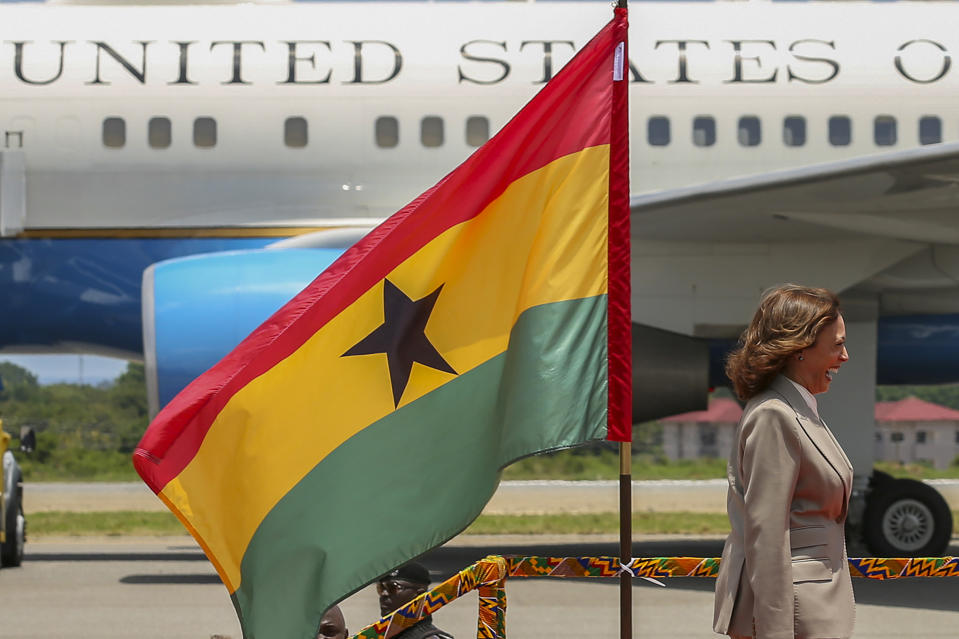 U.S. Vice President Kamala Harris smiles as she walks past a flag of Ghana upon her arrival in Accra, Ghana, Sunday March 26, 2023. Harris is on a seven-day African visit that will also take her to Tanzania and Zambia. (AP Photo/Misper Apawu)