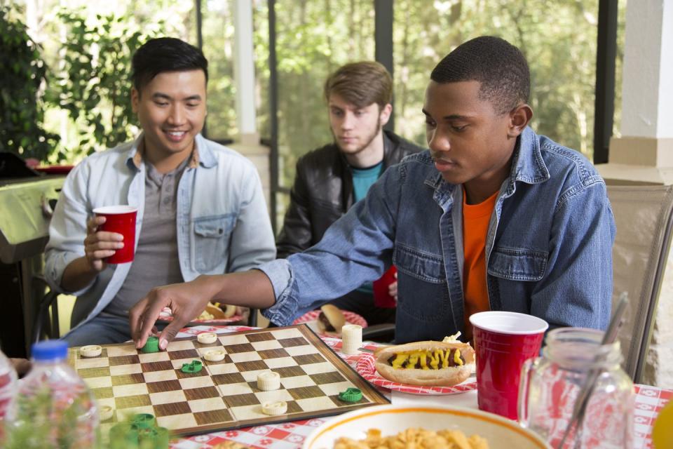 group of young men playing board game at a cookout 4th of july activities