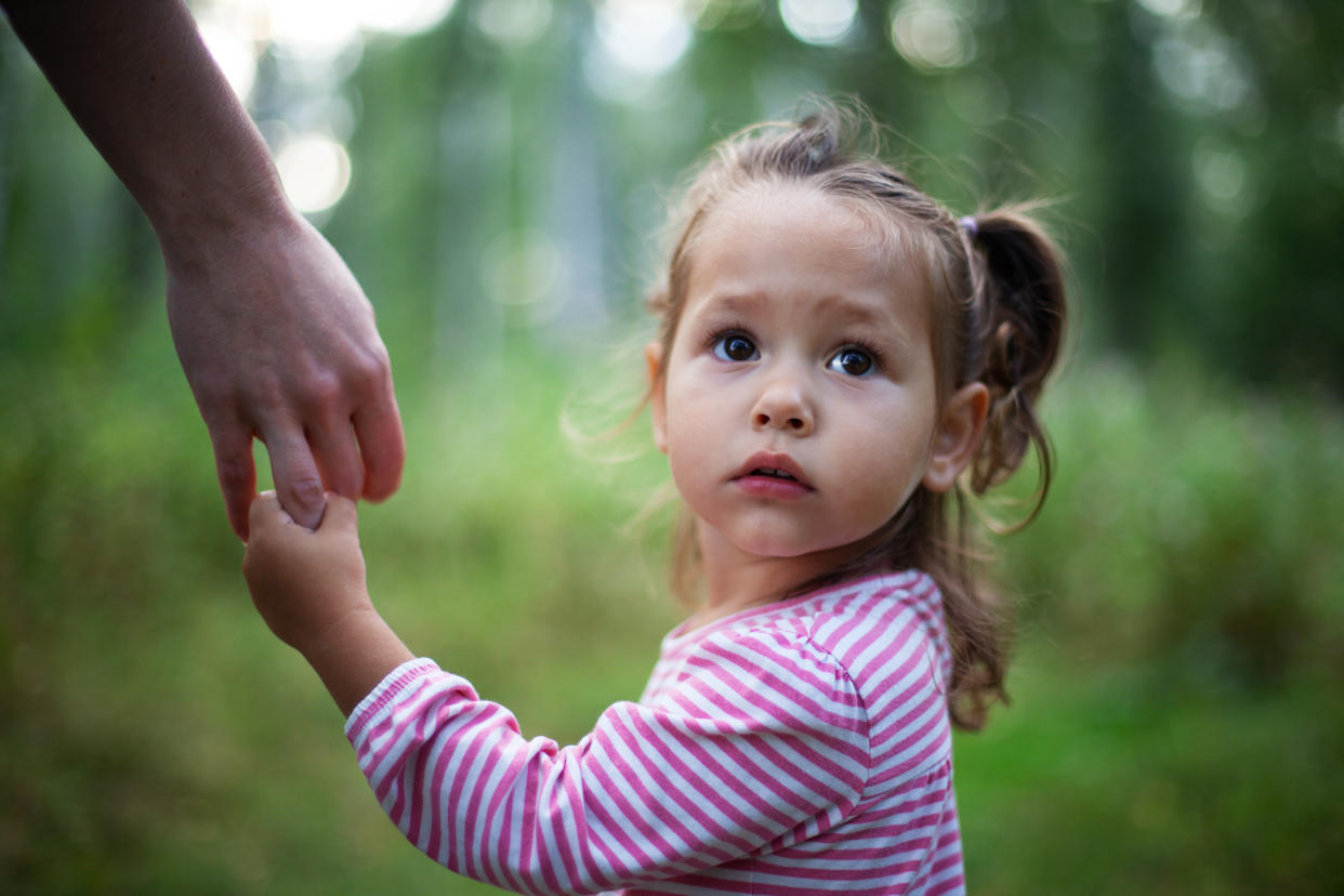 Little cute girl holding mother's hand< single parent, copy space