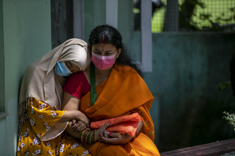 A physically disabled Nepalese girl waits with her mother to receive a dose of Johnson and Johnson vaccine at the Nepal Disabled Association Khagendra New Life Center in Kathmandu, Nepal, Monday, July 19, 2021. A shipment of 1.5 million doses of Johnson and Johnson vaccine donated by the United States arrived last week in Nepal, which is struggling to inoculate its population against the coronavirus. (AP Photo/Niranjan Shrestha)