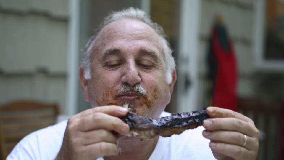 Hombre saboreando una costilla a la barbacoa