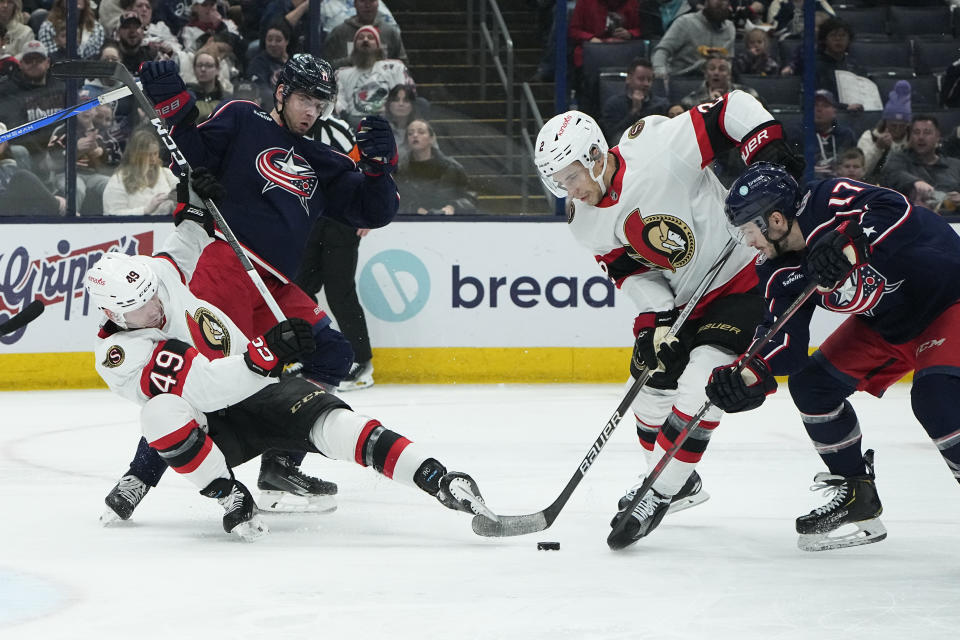 Ottawa Senators defenseman Artem Zub (2) and Columbus Blue Jackets right wing Justin Danforth (17) reach for the puck in front of Senators' Rourke Chartier (49) and Blue Jackets' Adam Fantilli (11) in the second period of an NHL hockey game Friday, Dec. 1, 2023, in Columbus, Ohio. (AP Photo/Sue Ogrocki)