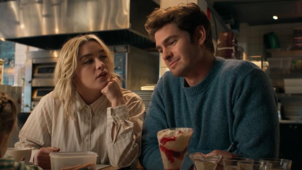  From left to right, Florence Pugh looking up at Andrew Garfield who is looking forward. 