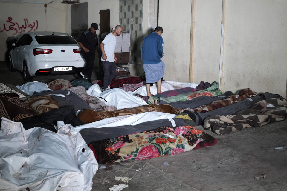 Palestinians look for their relatives killed in an Israeli bombardment of UNRWA school at Nusseirat refugee camp, in front of the morgue of al-Aqsa Martyrs hospital in Deir al-Balah, central Gaza Strip, early Thursday, June 6, 2024. (AP Photo/Abdel Kareem Hana)