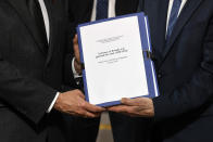 FILE - In this March 26, 2021 file photo, the report on the France's role in 1994's Rwandan genocide is given by Historian and Commission chief, Vincent Duclert to French President Emmanuel Macron, at the Elysee Palace, in Paris. France's role before and during 1994's Rwandan genocide was a "monumental failure" that the country must face, the lead author of a sweeping report commissioned by President Emmanuel Macron said, as the country is about to open its archives from this period for the first time to the public. (Ludovic Marin/Pool photo via AP, File)