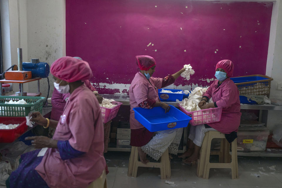 Employees of the Myna Mahila Foundation, a women's organization prepare sanitary pads at their office in Mumbai, India, Feb. 1, 2024. The organization is training a chatbot powered by artificial intelligence to answer women's questions about sexual reproductive health. The chatbot, currently a pilot project, represents what many hope will be part of the impact of AI on health care around the globe. (AP Photo/Rafiq Maqbool)