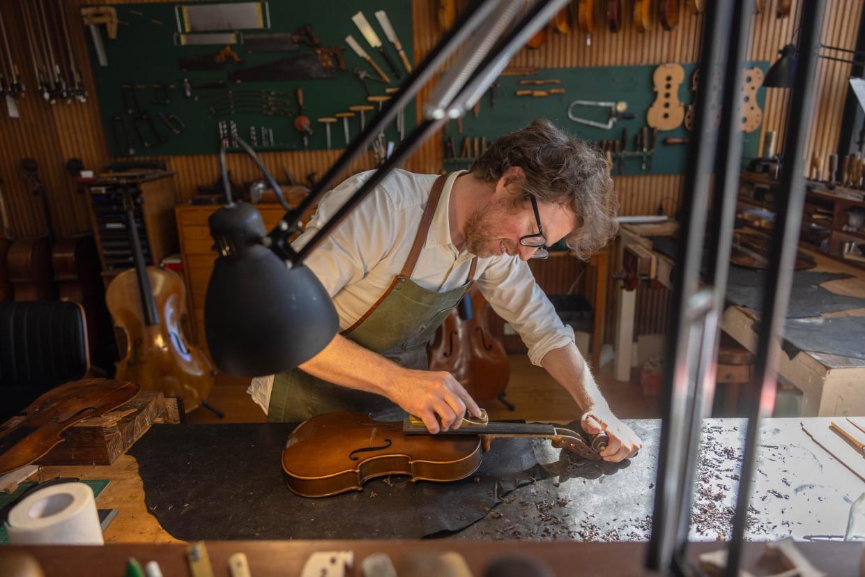 <span>Martin Paul repairs and restores violins, violas, cellos and their bows in his West Melbourne workshop.</span><span>Photograph: Ellen Smith/The Guardian</span>