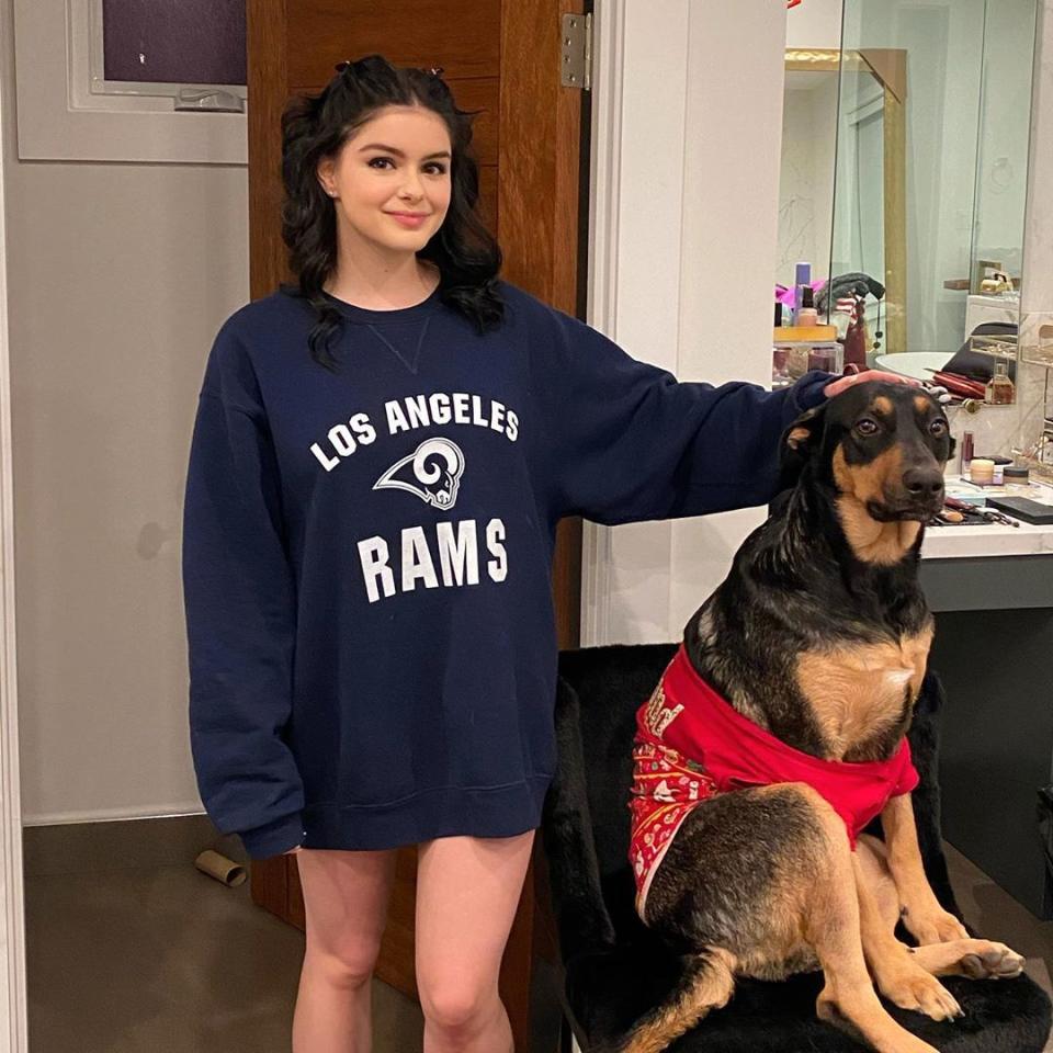 Ariel Winter poses in a sweatshirt with her dog