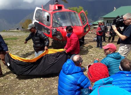 A body bag containing the body of a climber is carried from a helicopter in the Himalayan tourist town of Lukla April 29, 2015. REUTERS/Frank Jack Daniel