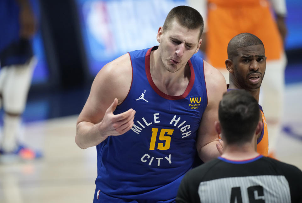 Denver Nuggets center Nikola Jokic, back left, argues for a call with referee Ben Taylor, front, as Phoenix Suns guard Chris Paul listens during the second half of Game 3 of an NBA second-round playoff series Friday, June 11, 2021, in Denver. Jokic was called for a technical foul. Phoenix won 116-102. (AP Photo/David Zalubowski)