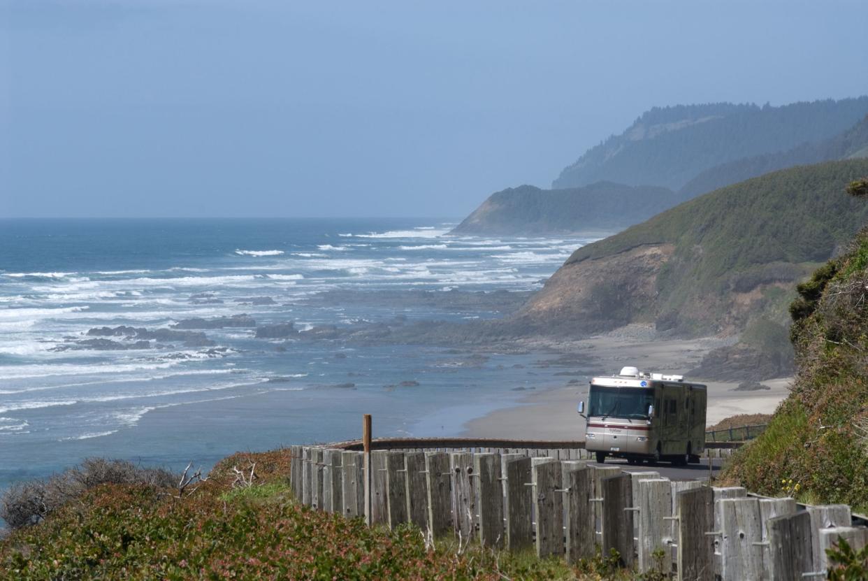 RV traveling along Highway 101 of the Oregon Coast with ocean and coastline in the background