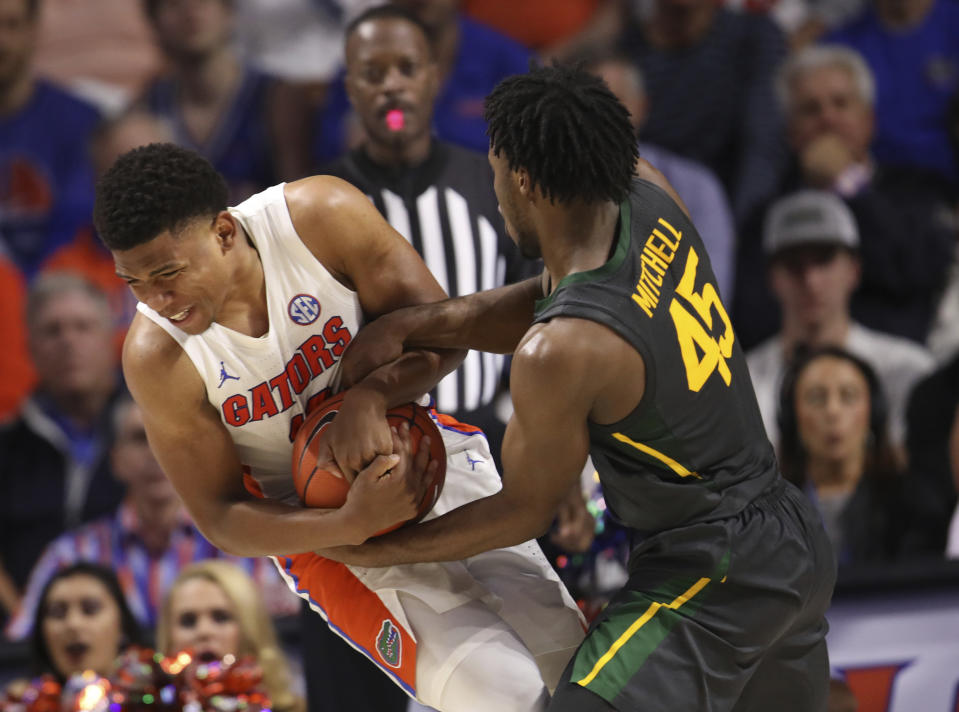 Baylor guard Davion Mitchell (45) forces a jump ball with Florida guard Noah Locke (10) during the second half of an NCAA college basketball game Saturday, Jan. 25, 2020, in Gainesville, Fla. (AP Photo/Matt Stamey)