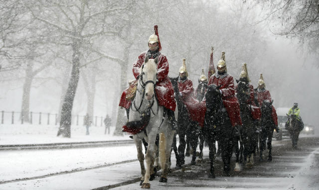 Members of the Household Cavalry return to their barracks as snow falls in London, Wednesday, Feb. 28, 2018. Britain, which is buffered by the Atlantic Ocean and tends to have temperate winters, saw heavy snow in some areas that disrupted road, rail and air travel and forced hundreds of schools to close. (AP Photo/Alastair Grant)