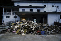 FILE - Piles of debris and mud cover a road after massive flooding Aug. 5, 2022, in Lost Creek, Ky. Gov. Andy Beshear pointed to signs of progress Thursday, Aug. 18, as federal emergency personnel respond to requests for assistance in flood-ravaged eastern Kentucky, but stressed it is “still not enough” as people work to recover from the disaster that swept away homes and inundated communities. (AP Photo/Brynn Anderson, File)