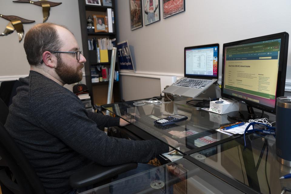 Ethan Miller works on his taxes at home in Silver Spring, Md., Friday, Jan., 21, 2022. Tax filing season starts Monday and people can expect the task to be more cumbersome than usual this year thanks to an overloaded and understaffed IRS workforce and new complications from pandemic-related programs.(AP Photo/Jacquelyn Martin)