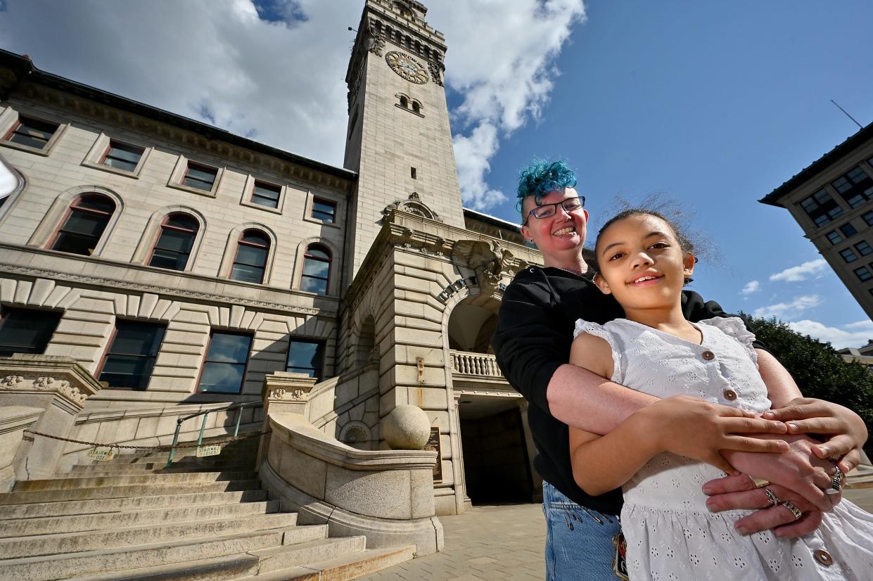 Ciara Barber, who has visited all 351 city and town halls in Massachusetts, poses outside Worcester City Hall with her mother, Blue.