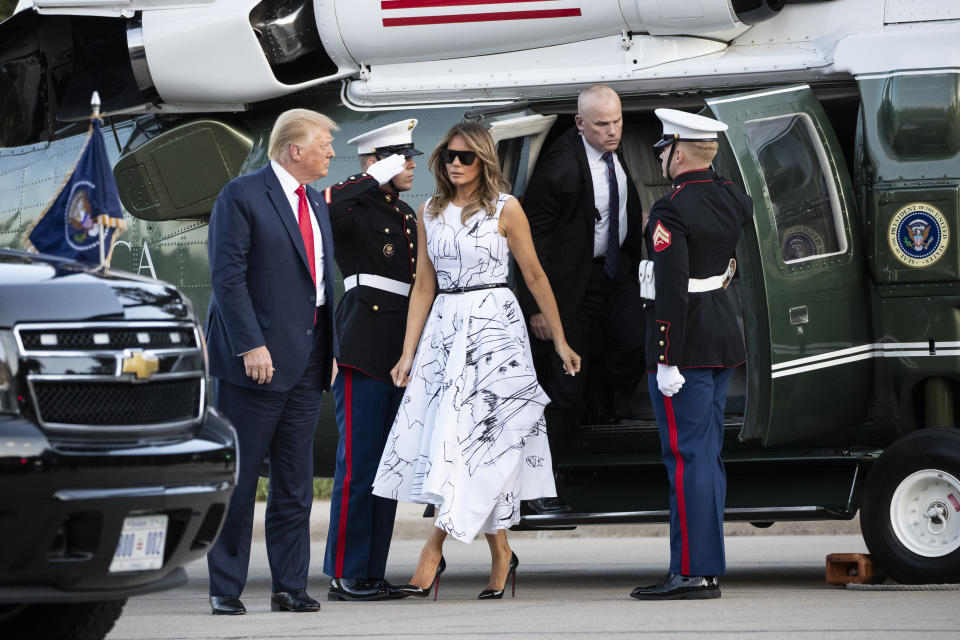 FILE - In this Friday, July 3, 2020 file photo, President Donald Trump, accompanied by first lady Melania Trump, step off Marine One as they arrive at Mount Rushmore National Memorial near Keystone, S.D. On Friday, July 10, 2020, The Associated Press reported on stories circulating online incorrectly asserting the dress Melania Trump wore during Fourth of July celebrations featured drawings by various victims of child sex trafficking. The sketches on the dress were made by design students from the British art school Central Saint Martins. (AP Photo/Alex Brandon)