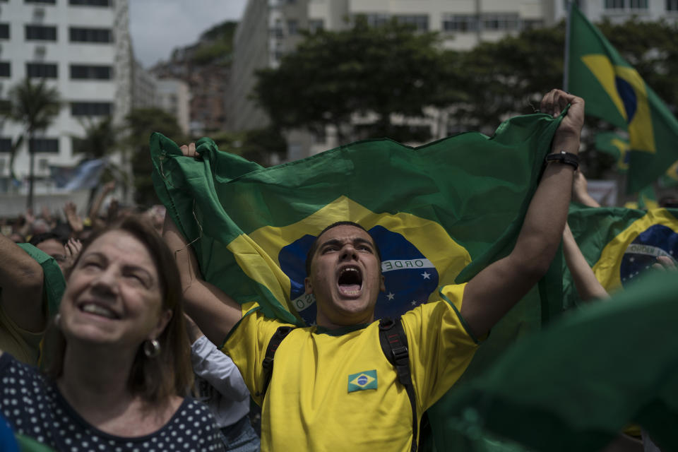 A man yells after listening to the Brazil's anthem during a campaign rally for presidential candidate Jair Bolsonaro, of the far-right Social Liberal Party, in Copacabana in Rio de Janeiro, Brazil, Sunday, Oct. 21, 2018. The rally took place one week before Brazilians return to the polls on Oct. 28 for a second round of voting. (AP Photo/Leo Correa)