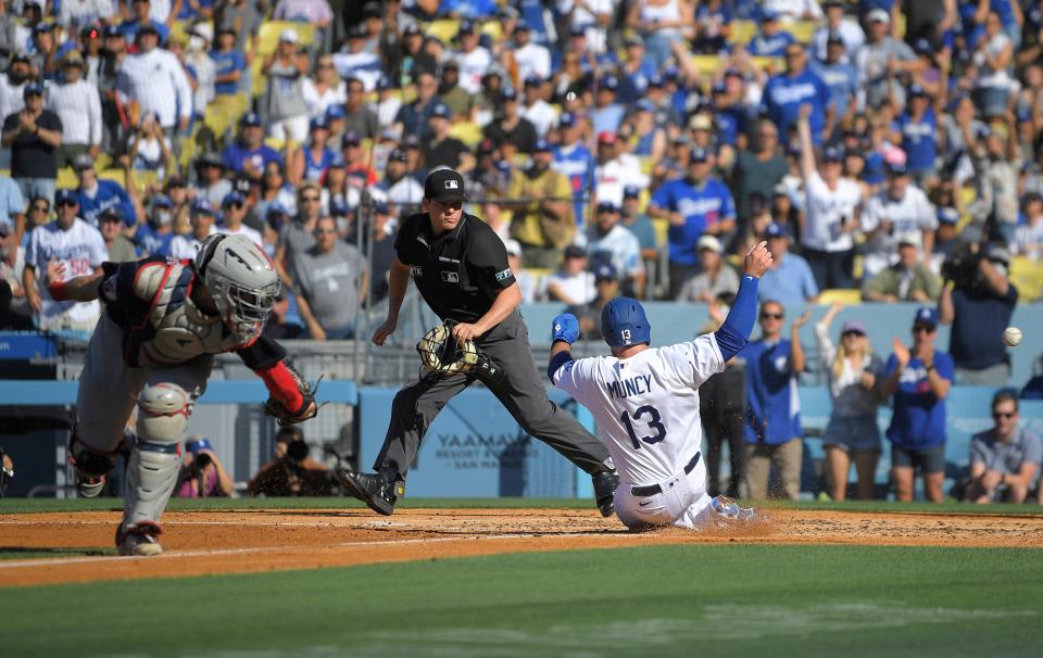 Los Angeles Dodgers baserunner Max Muncy, right, scores on a double by Justin Turner as the ball gets past Guardians catcher Austin Hedges, left, in the third inning of the Dodgers' 7-1 win Saturday in Los Angeles. [Mark J. Terrill/Associated Press]