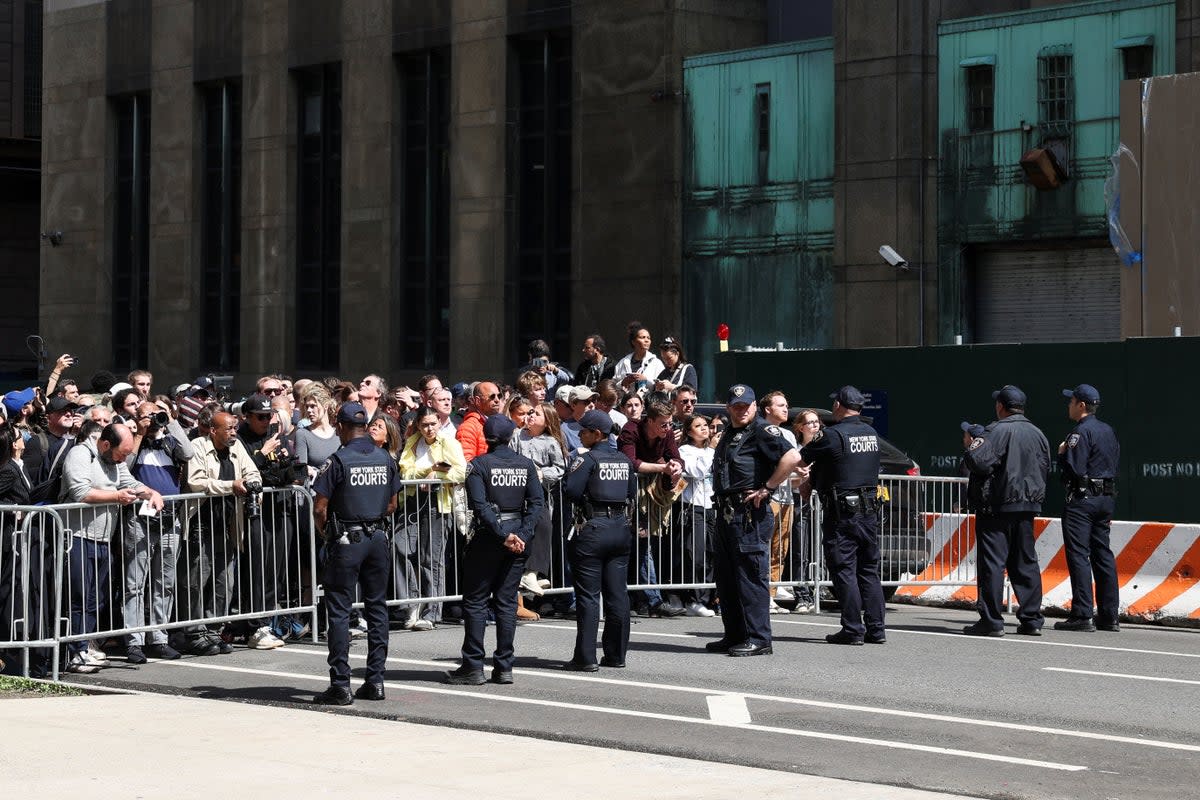 Law enforcement officers stand guard as people gather outside Manhattan Criminal Courthouse on Tuesday during Donald Trump’s arraignment (REUTERS)