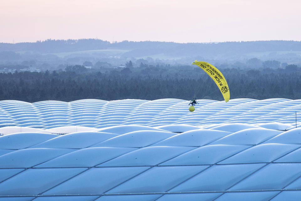 A man in a Greenpeace paraglider flies into the stadium prior to the Euro 2020 soccer championship group F match between France and Germany at the Allianz Arena stadium in Munich, Tuesday, June 15, 2021. (Matthias Balk/DPA via AP)