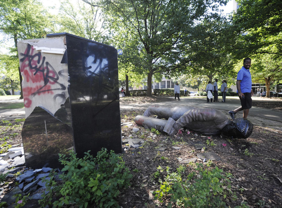 An unidentified man walks past a toppled statue of Charles Linn, a city founder who was in the Confederate Navy, in Birmingham, Ala., on Monday, June 1, 2020, following a night of unrest. (Jay Reeves/AP Photo)