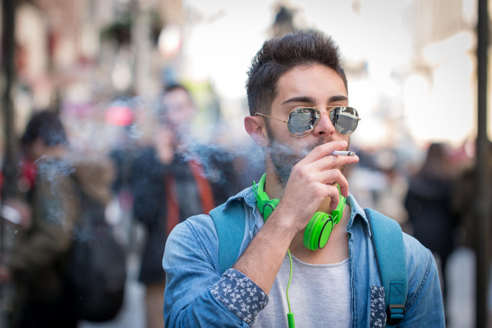 A young man smokes a cigarette.