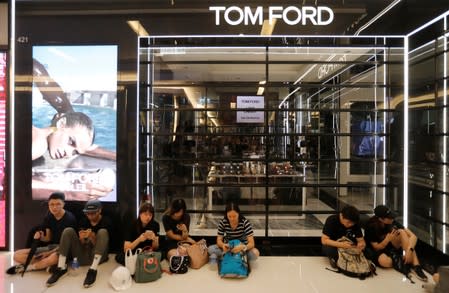 Demonstrators sit outside a close shop as they attend a rally to support the city-wide strike and to call for democratic reforms at New Town Plaza shopping mall in Hong Kong