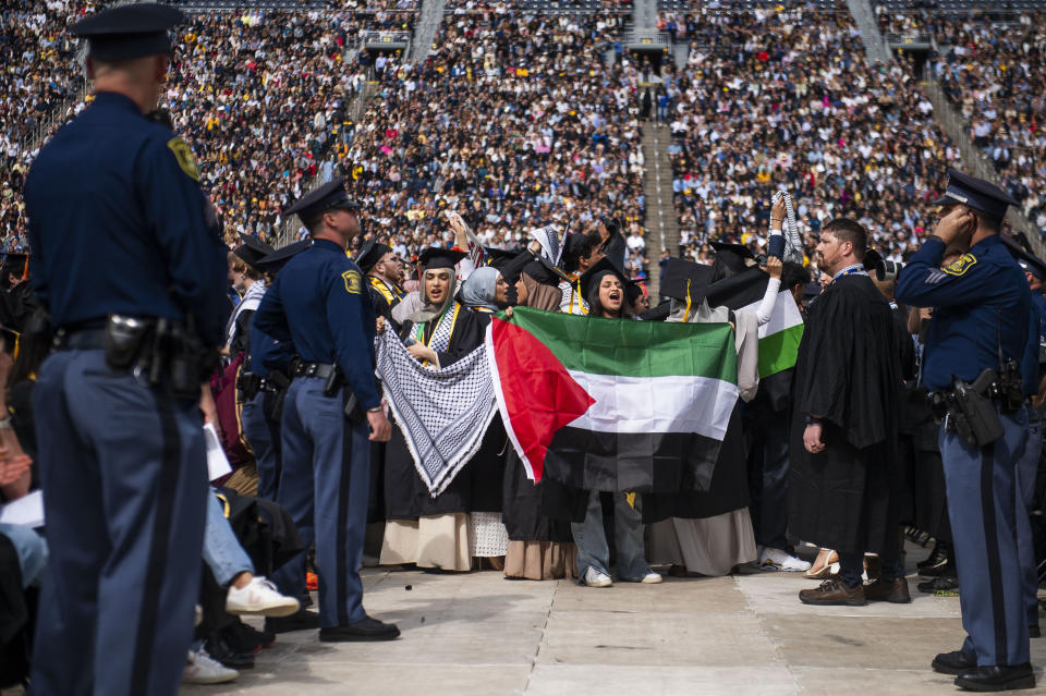 Rawan Antar, de 21 años (centro), grita consignas en apoyo a los palestinos durante la ceremonia de graduación de la Universidad de Michigan, el sábado 4 de mayo de 2024, en Ann Arbor, Michigan. (Katy Kildee/Detroit News vía AP)