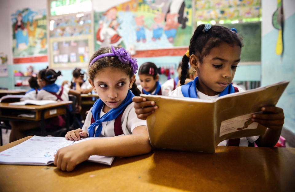 Cuban schoolgirls read during class on November 13, 2012 in Havana.