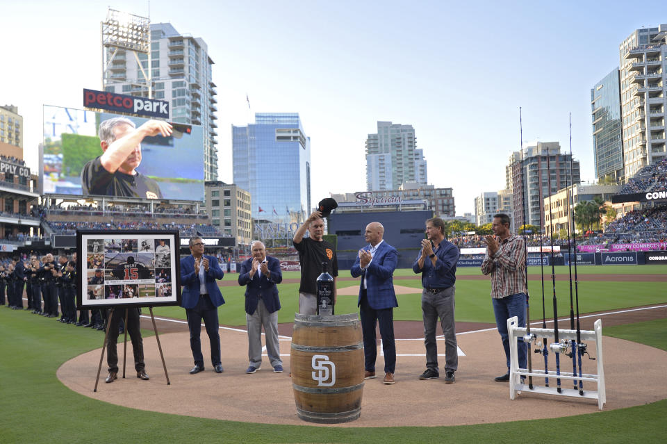 San Francisco Giants' Bruce Bochy, center, acknowledges the crowd during a retirement ceremony in his honor before a baseball game against the San Diego Padres, Friday, July 26, 2019, in San Diego. Bochy will retire at the end of the season and is playing his last regular season series in San Diego. (AP Photo/Orlando Ramirez)