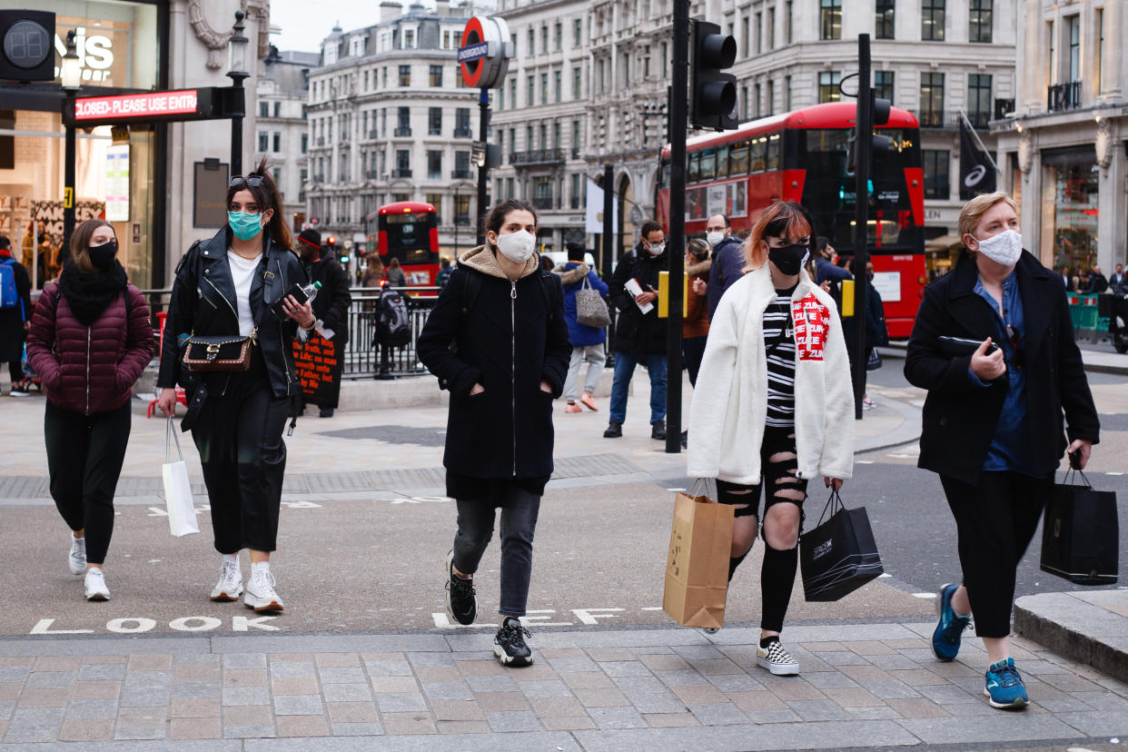 People wearing face masks cross Oxford Circus in London, England, on October 16, 2020. London is to be placed under 'Tier 2' coronavirus lockdown measures from midnight tonight, meaning 'high' alert for covid-19. Most notably the change will introduce a ban on people from different households from mixing anywhere indoors, prompting particular concern within the already badly-affected hospitality industry. (Photo by David Cliff/NurPhoto via Getty Images)