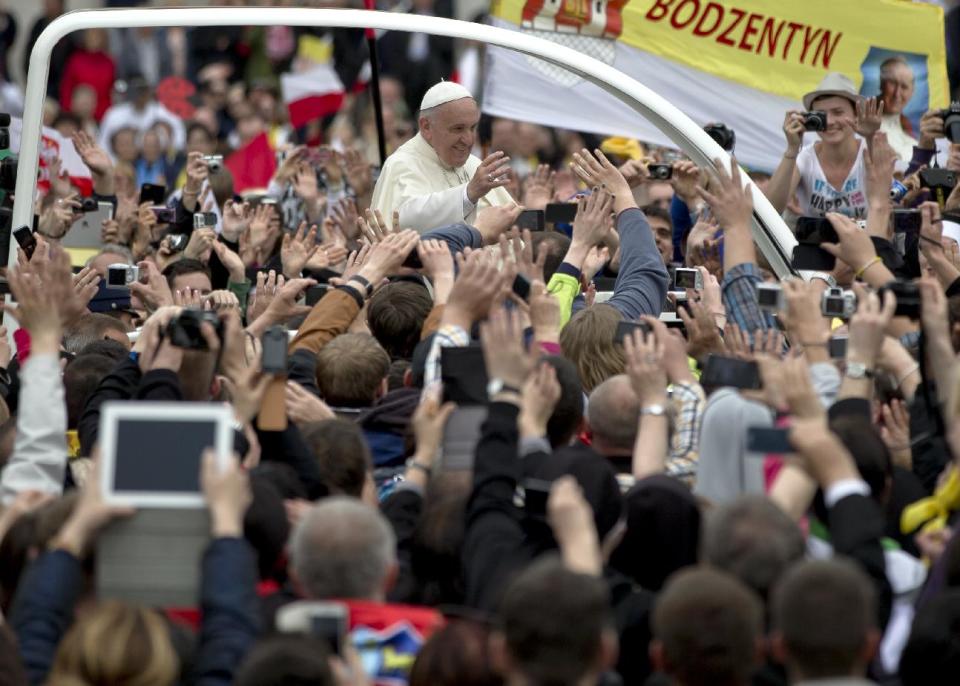 Pope Francis is driven through the crowd in St. Peter's Square at the Vatican, Sunday, April 27, 2014. Pope Francis has declared his two predecessors John XXIII and John Paul II saints in an unprecedented canonization ceremony made even more historic by the presence of retired Pope Benedict XVI. (AP Photo/Vadim Ghirda)