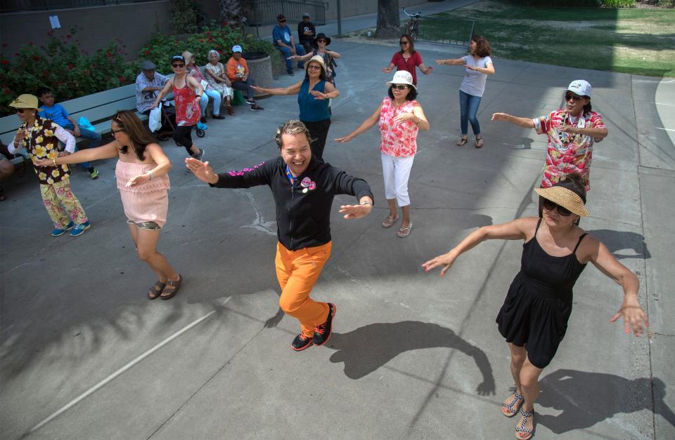 Eison Balanay, center, leads a group of spectators in a Zumba lesson at the annual Barrio Fiesta held a the Filipino Plaza Center in downtown Stockton on Aug. 12, 2017.