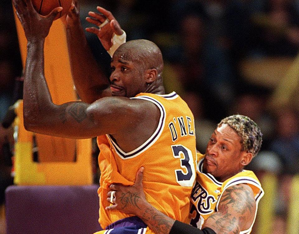 LOS ANGELES, UNITED STATES:  Shaquille O'Neal of the Los Angeles Lakers (L) grabs a rebound over teammate Dennis Rodman during their 05 March game against the Seattle SuperSonics in Los Angeles, Ca. O'Neal scored 31 points and the Lakers went on to win the game, 103-100.  AFP PHOTO  Vince BUCCI (Photo credit should read Vince Bucci/AFP via Getty Images)