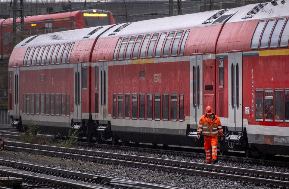 A railway worker walks along a parked train outside the central train station in Frankfurt, Germany, Monday, March 11, 2024. German train drivers union GDL called for another strike starting early Tuesday. (AP Photo/Michael Probst)
