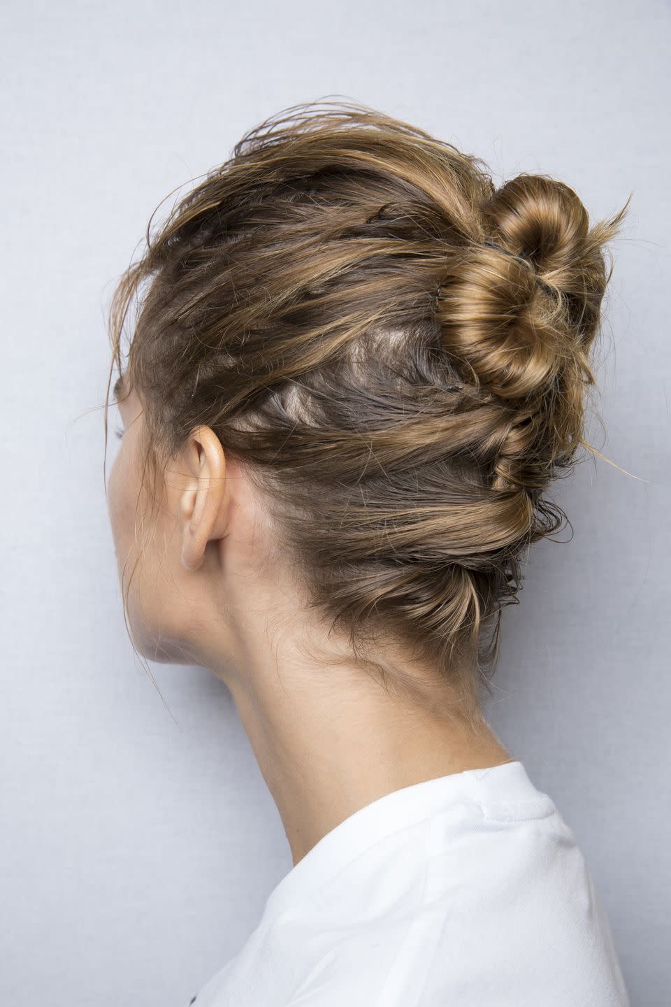 <p>A simple twisted chignon looks even cooler when the twists continue down the nape of the neck, as seen at Emporio Armani.</p>