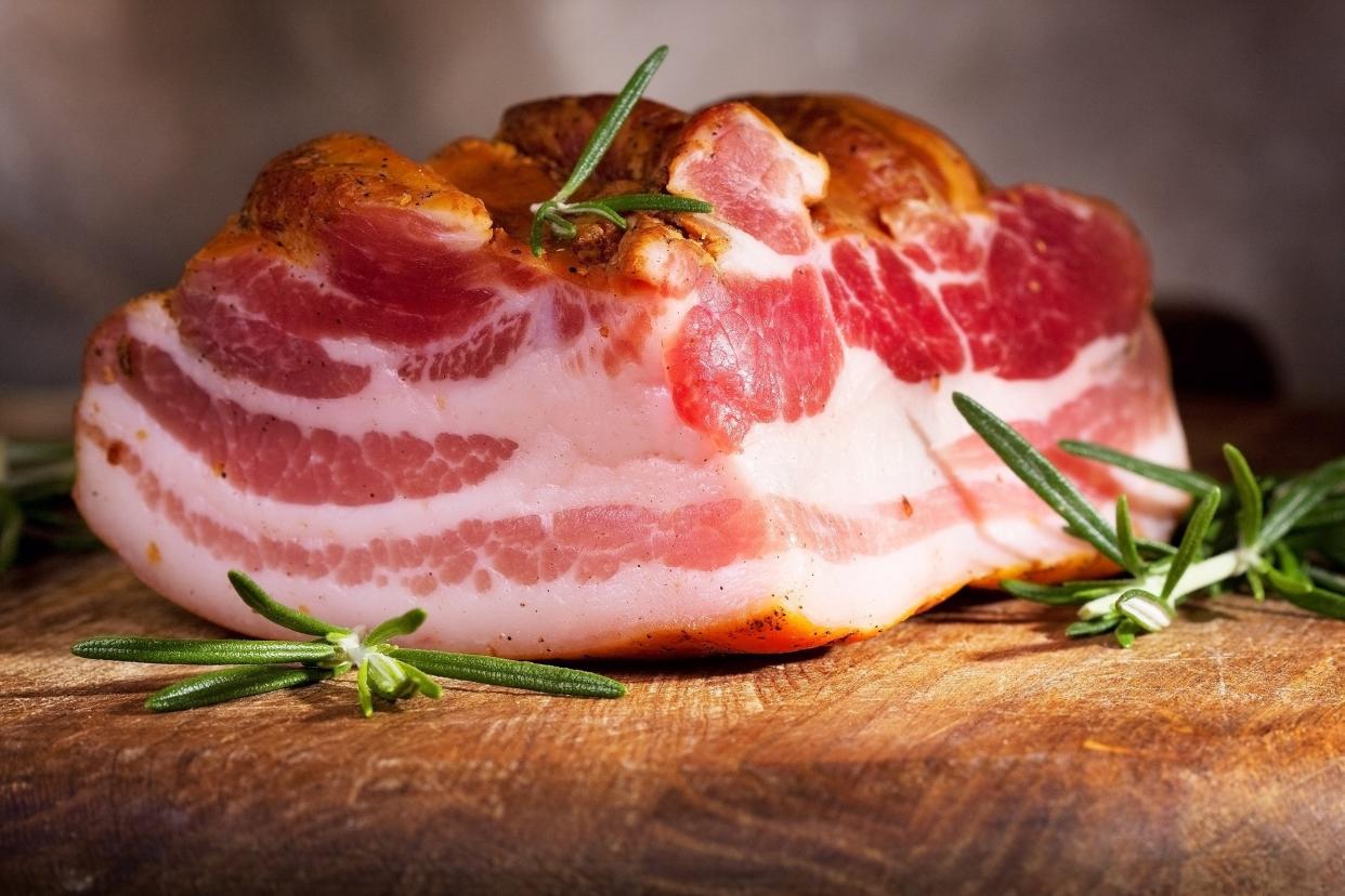 smoked bacon with rosemary on wooden table